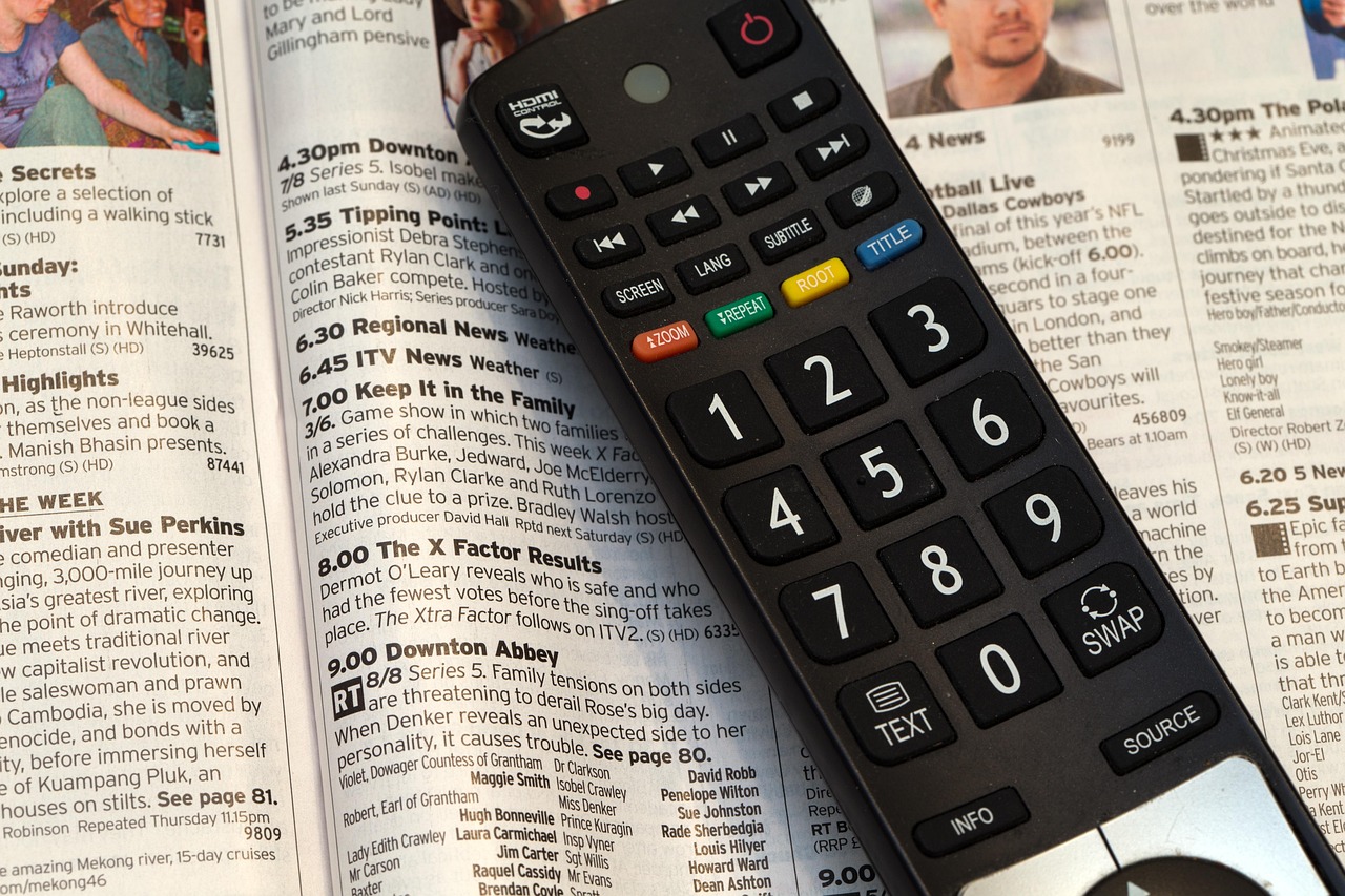 A television remote control resting on a table in front of a screen, similar to the Fire TV remote used during setup.